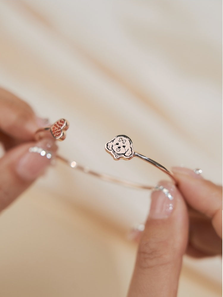  A close-up of a Custom Pet Portrait Bracelet featuring a personalized charm in 925 silver, displaying a detailed pet portrait. The bracelet showcases intricate craftsmanship and an adjustable chain, symbolizing a cherished bond between pet and owner. Ideal as a pet memorial or keepsake, crafted with care and precision.