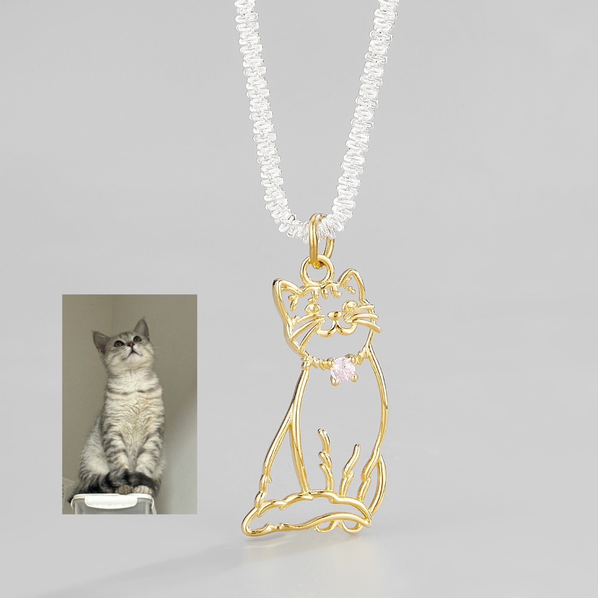 A delicate custom pet portrait necklace featuring a 925 silver pendant with a detailed outline of a cat. The necklace is elegantly displayed on a white jewelry stand, highlighting its intricate design and craftsmanship. This personalized pet jewelry piece serves as a beautiful keepsake for pet lovers, capturing the essence of their furry friends in silver.