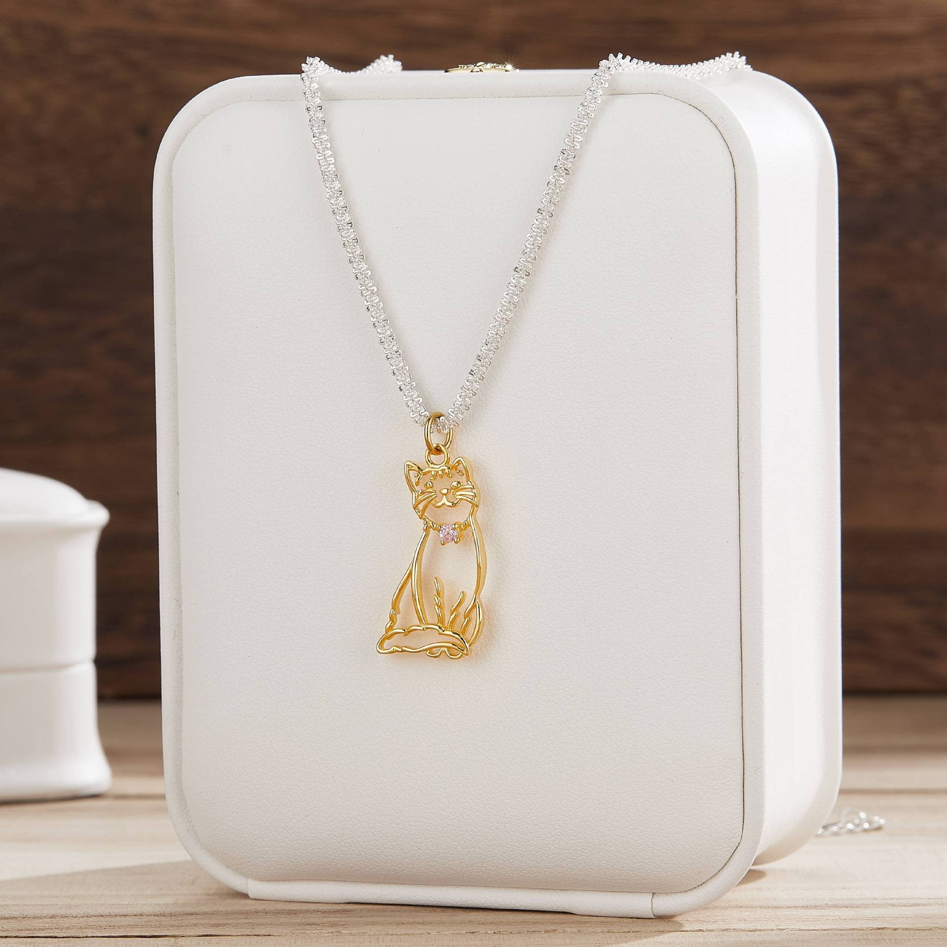 A delicate custom pet portrait necklace featuring a 925 silver pendant with a detailed outline of a cat. The necklace is elegantly displayed on a white jewelry stand, highlighting its intricate design and craftsmanship. This personalized pet jewelry piece serves as a beautiful keepsake for pet lovers, capturing the essence of their furry friends in silver.
