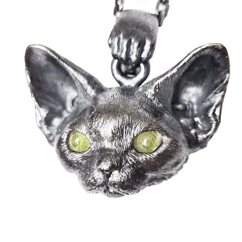 This image showcases the Devon Bobcat Silver Pendant, a beautifully handcrafted pet memorial necklace made from 925 sterling silver. The pendant features lifelike details of the Devon Bobcat, with carefully set gemstone eyes that add a unique touch. Due to the handcrafted nature, each piece has slight variations, making it one-of-a-kind. Custom engraving is available to personalize the pendant as a cherished keepsake. The image highlights the fine craftsmanship and delicate details that make this pendan