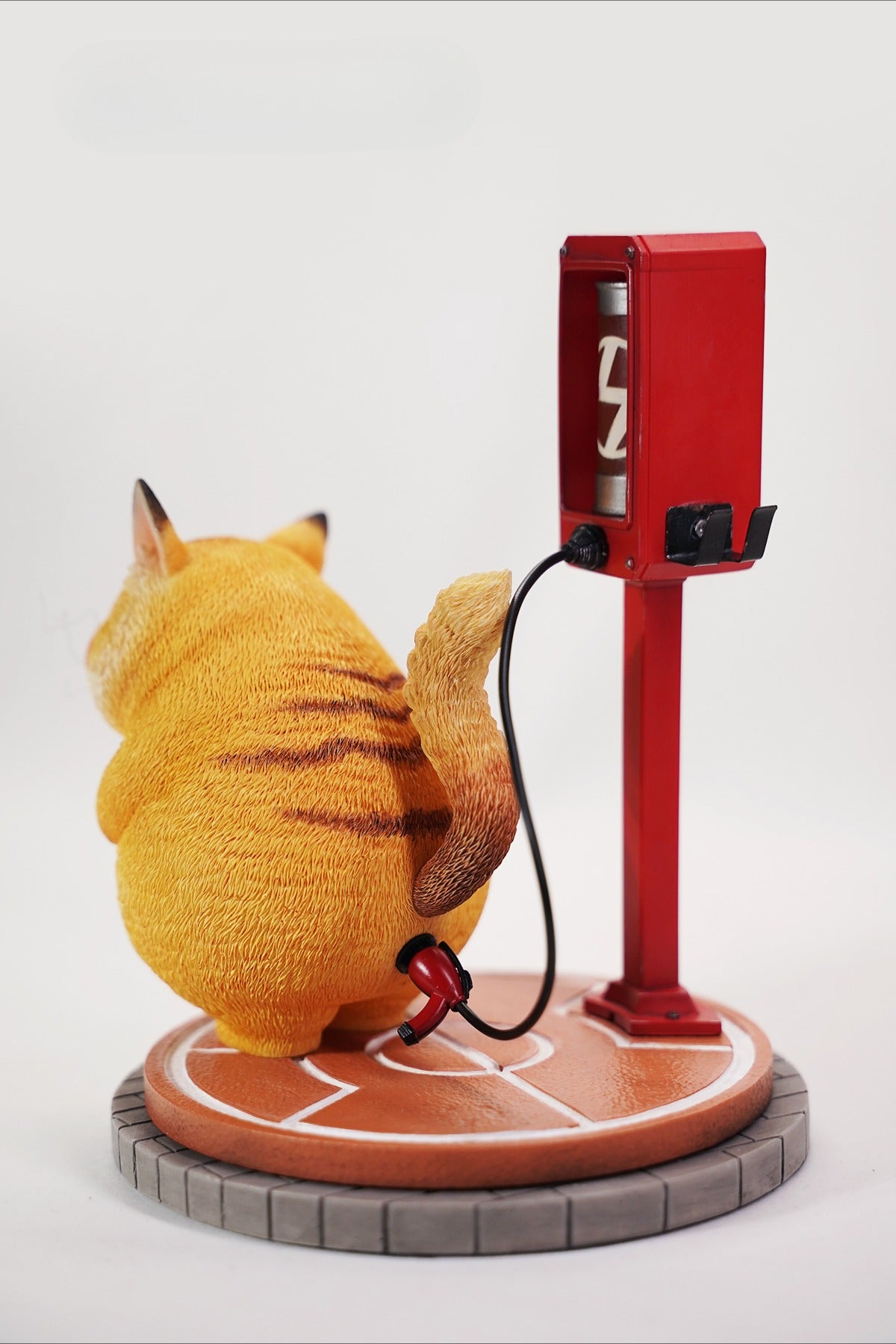 This ElectroCat Charging Station Figurine features a cute cat with a charging pump made from high-quality vinyl. The charging platform adds functionality, allowing the figurine to light up, making it a unique home decor piece and interactive collectible for cat lovers and collectors.