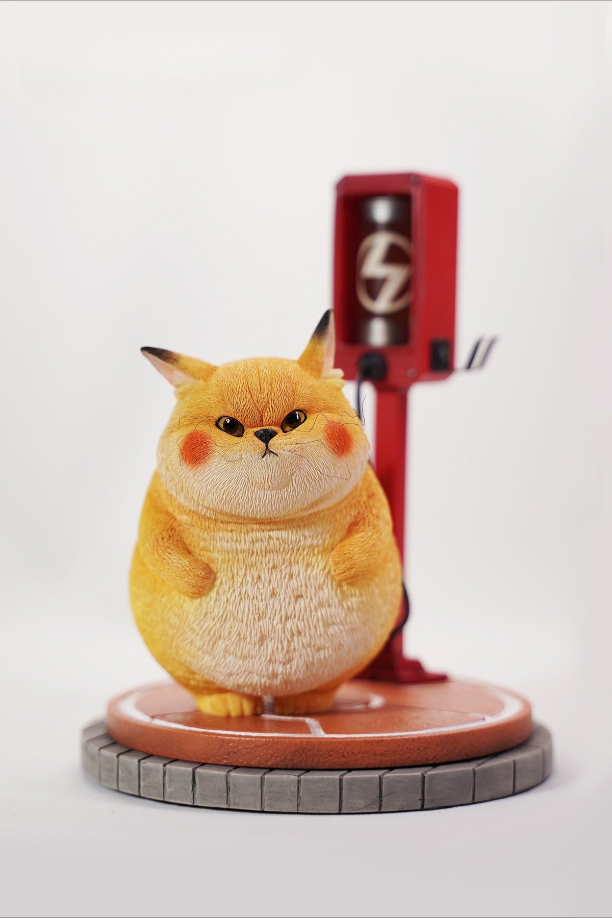 This ElectroCat Charging Station Figurine features a cute cat with a charging pump made from high-quality vinyl. The charging platform adds functionality, allowing the figurine to light up, making it a unique home decor piece and interactive collectible for cat lovers and collectors.