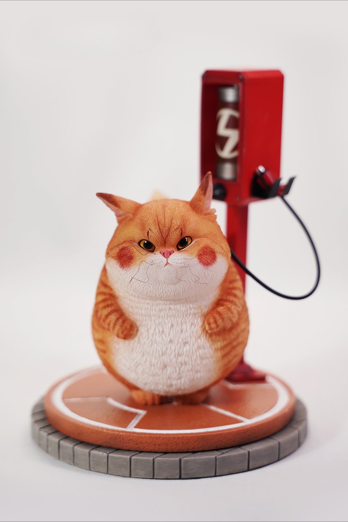 This ElectroCat Charging Station Figurine features a cute cat with a charging pump made from high-quality vinyl. The charging platform adds functionality, allowing the figurine to light up, making it a unique home decor piece and interactive collectible for cat lovers and collectors.