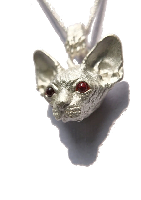 A handcrafted Sphynx cat pendant and ring set in 925 sterling silver, featuring customizable gemstone eyes and available in both silver and antique black finishes. This unique jewelry piece is perfect for Sphynx cat lovers and as a personalized pet memorial.