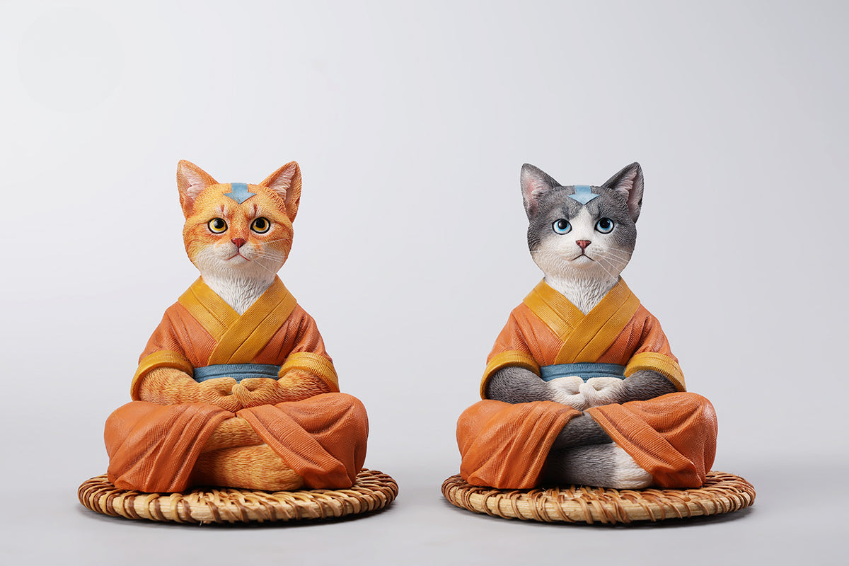 A handcrafted Airbender Cat Figurine in a meditative pose, dressed in an orange robe with a blue sash, sitting on a rattan-weaved cushion. This finely detailed resin sculpture captures the tranquility of mindfulness, perfect for cat lovers and meditation enthusiasts. An ideal collectible and decorative accent for any serene space.