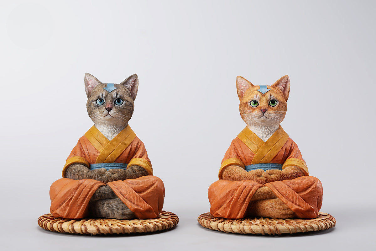 A handcrafted Airbender Cat Figurine in a meditative pose, dressed in an orange robe with a blue sash, sitting on a rattan-weaved cushion. This finely detailed resin sculpture captures the tranquility of mindfulness, perfect for cat lovers and meditation enthusiasts. An ideal collectible and decorative accent for any serene space.