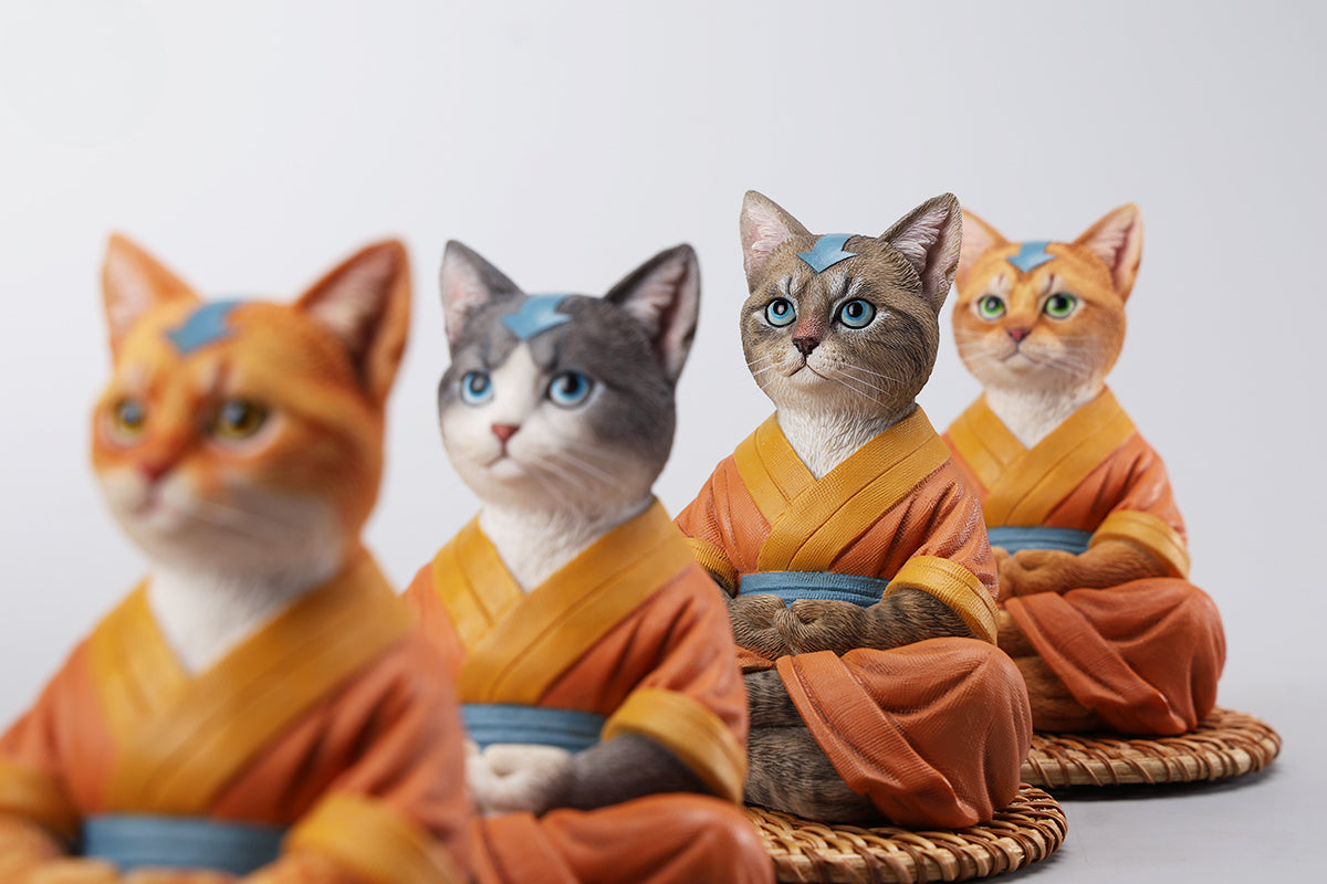 A handcrafted Airbender Cat Figurine in a meditative pose, dressed in an orange robe with a blue sash, sitting on a rattan-weaved cushion. This finely detailed resin sculpture captures the tranquility of mindfulness, perfect for cat lovers and meditation enthusiasts. An ideal collectible and decorative accent for any serene space.