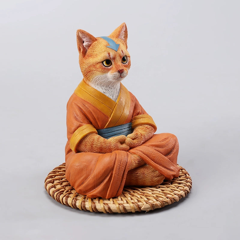 A handcrafted Airbender Cat Figurine in a meditative pose, dressed in an orange robe with a blue sash, sitting on a rattan-weaved cushion. This finely detailed resin sculpture captures the tranquility of mindfulness, perfect for cat lovers and meditation enthusiasts. An ideal collectible and decorative accent for any serene space.