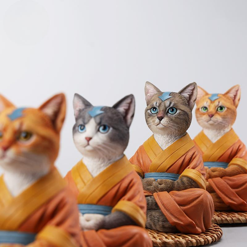 A handcrafted Airbender Cat Figurine in a meditative pose, dressed in an orange robe with a blue sash, sitting on a rattan-weaved cushion. This finely detailed resin sculpture captures the tranquility of mindfulness, perfect for cat lovers and meditation enthusiasts. An ideal collectible and decorative accent for any serene space.