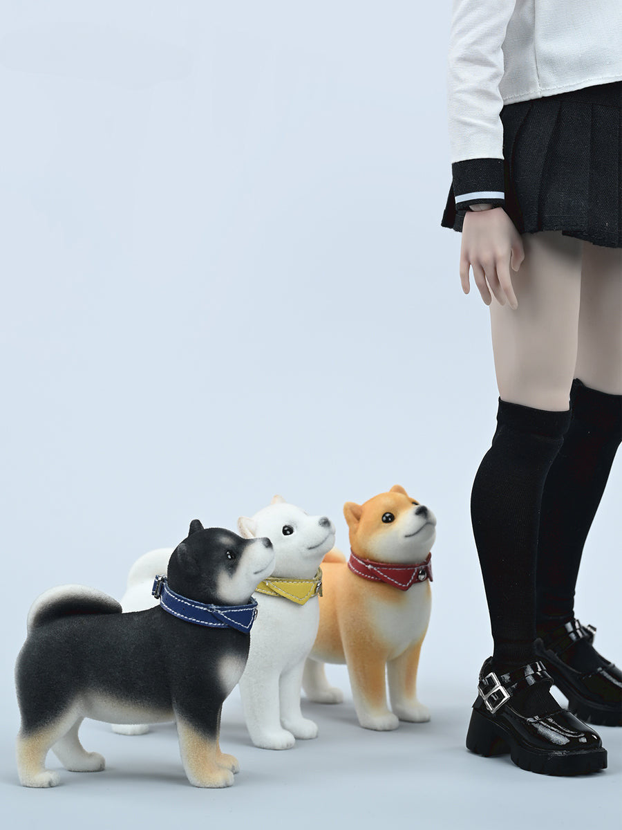 A set of three flocking Shiba Inu dog models in different colors - black, white, and tan. Each model features a realistic and adorable design with a collar in different colors: blue, yellow, and red. The dogs are shown in various poses, including waving, standing, and sitting.