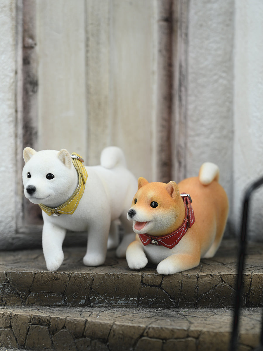 A set of three flocking Shiba Inu dog models in different colors - black, white, and tan. Each model features a realistic and adorable design with a collar in different colors: blue, yellow, and red. The dogs are shown in various poses, including waving, standing, and sitting.