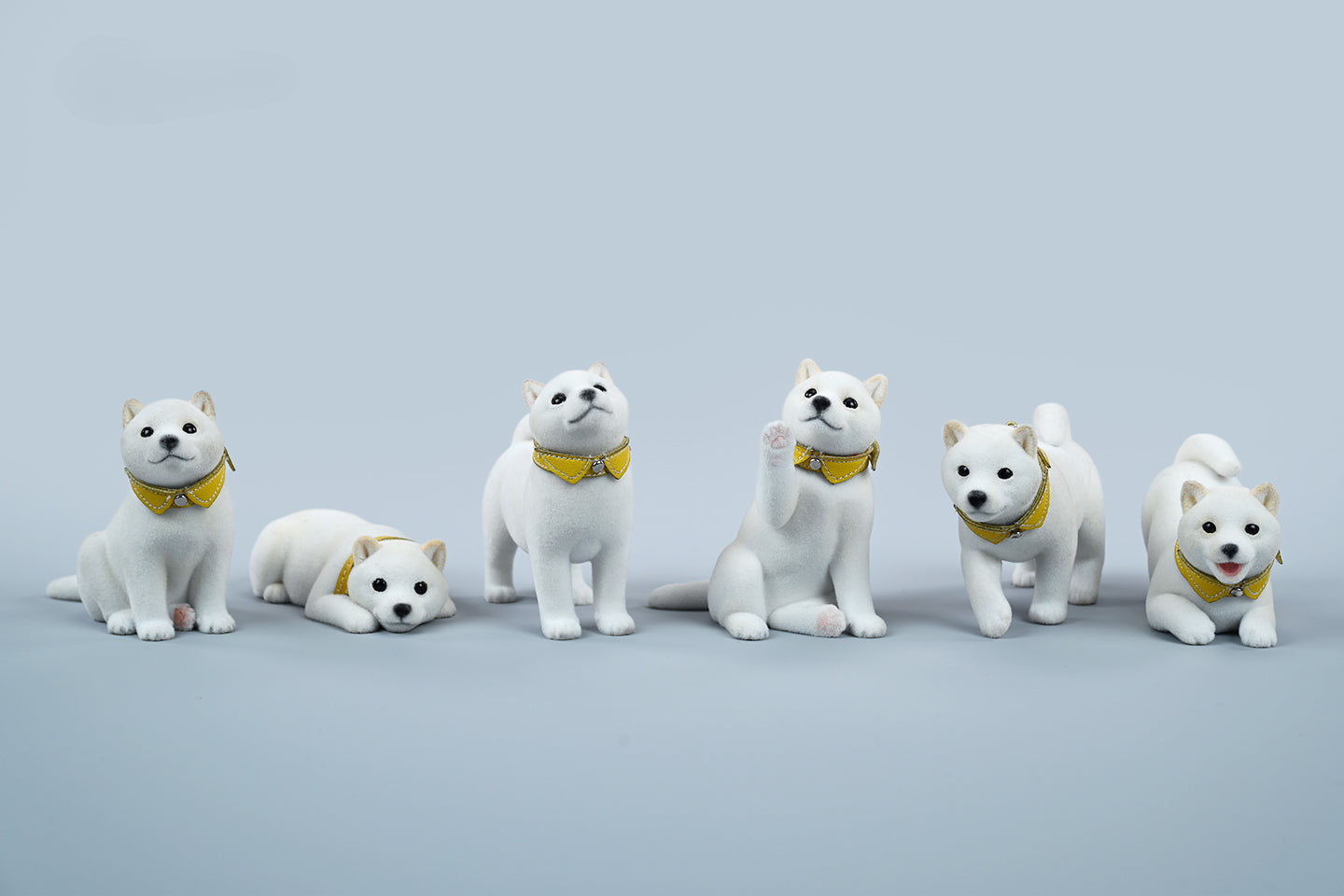 A set of three flocking Shiba Inu dog models in different colors - black, white, and tan. Each model features a realistic and adorable design with a collar in different colors: blue, yellow, and red. The dogs are shown in various poses, including waving, standing, and sitting.