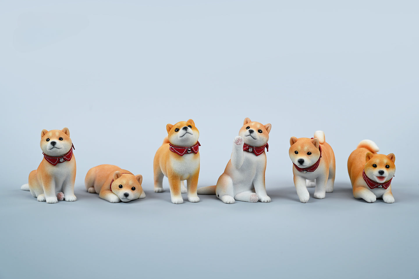 A set of three flocking Shiba Inu dog models in different colors - black, white, and tan. Each model features a realistic and adorable design with a collar in different colors: blue, yellow, and red. The dogs are shown in various poses, including waving, standing, and sitting.