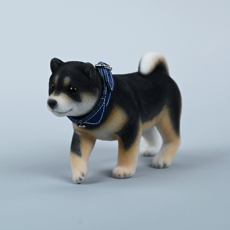 A set of three flocking Shiba Inu dog models in different colors - black, white, and tan. Each model features a realistic and adorable design with a collar in different colors: blue, yellow, and red. The dogs are shown in various poses, including waving, standing, and sitting.