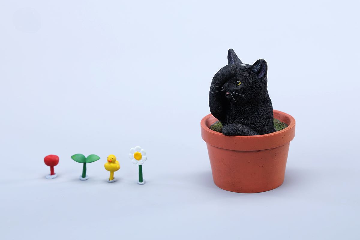 This charming Flower Pot Cat Model features a playful kitten peeking out of a terracotta pot with a small yellow rubber duck on its head. The series includes multiple variations, each with a different accessory atop the cat's head. This delightful ornament brings a touch of whimsy and cheer to any space, perfect for cat lovers and collectors alike. The detailed craftsmanship and vibrant colors make it a standout piece in any collection.