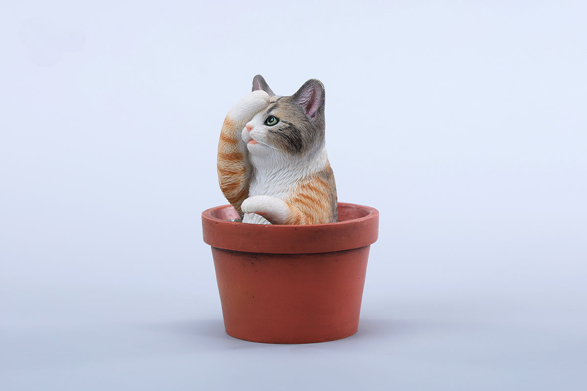 This charming Flower Pot Cat Model features a playful kitten peeking out of a terracotta pot with a small yellow rubber duck on its head. The series includes multiple variations, each with a different accessory atop the cat's head. This delightful ornament brings a touch of whimsy and cheer to any space, perfect for cat lovers and collectors alike. The detailed craftsmanship and vibrant colors make it a standout piece in any collection.