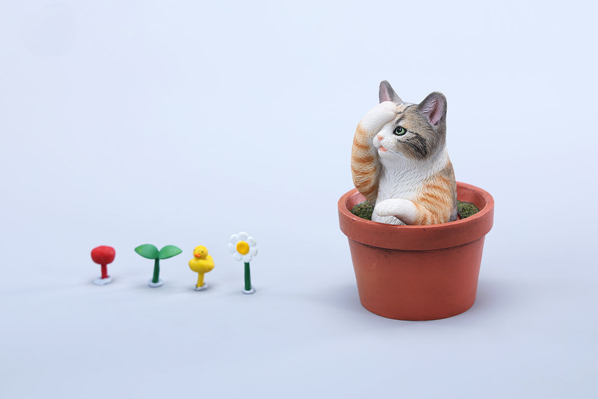 This charming Flower Pot Cat Model features a playful kitten peeking out of a terracotta pot with a small yellow rubber duck on its head. The series includes multiple variations, each with a different accessory atop the cat's head. This delightful ornament brings a touch of whimsy and cheer to any space, perfect for cat lovers and collectors alike. The detailed craftsmanship and vibrant colors make it a standout piece in any collection.