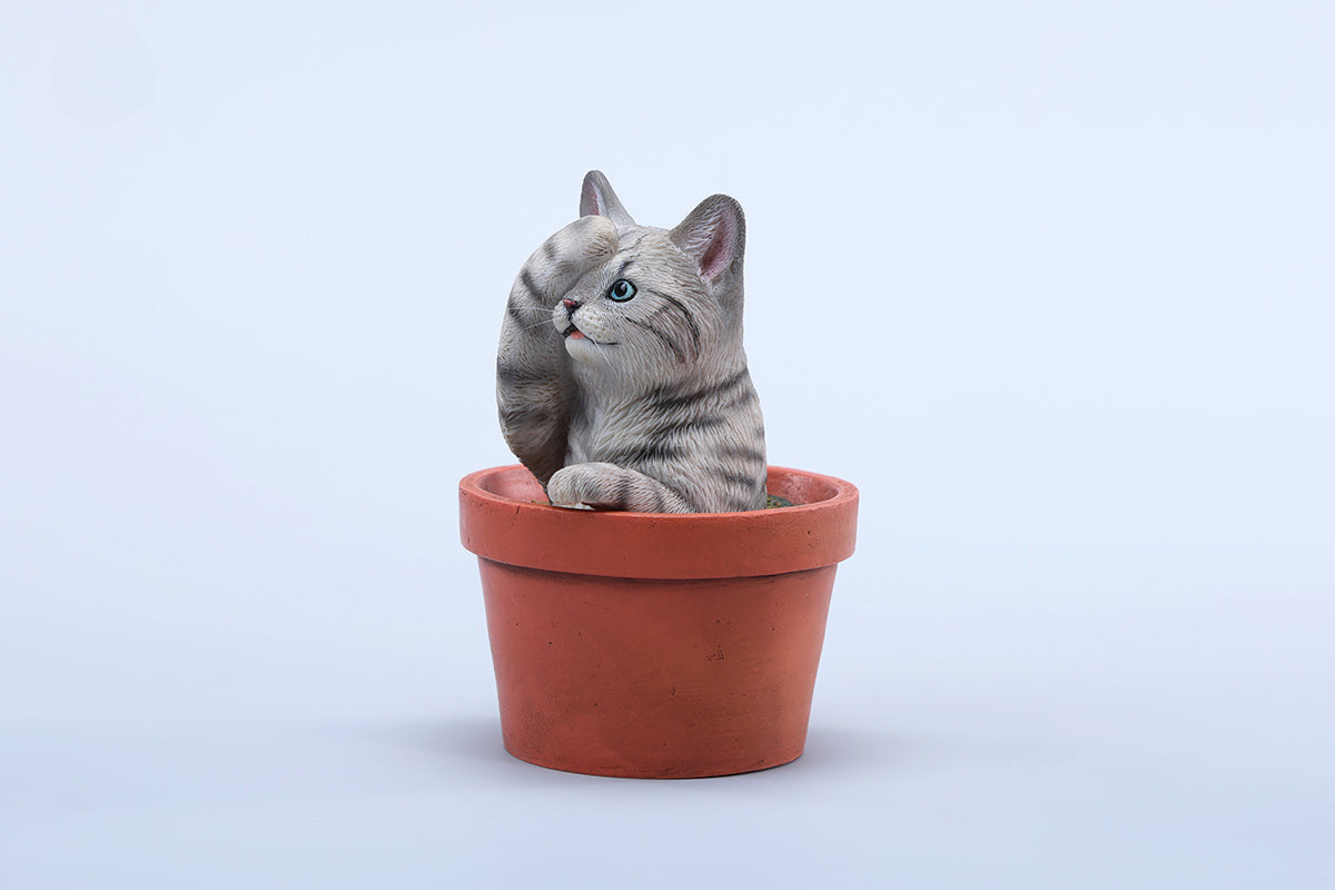 This charming Flower Pot Cat Model features a playful kitten peeking out of a terracotta pot with a small yellow rubber duck on its head. The series includes multiple variations, each with a different accessory atop the cat's head. This delightful ornament brings a touch of whimsy and cheer to any space, perfect for cat lovers and collectors alike. The detailed craftsmanship and vibrant colors make it a standout piece in any collection.