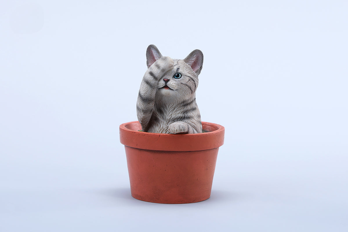 This charming Flower Pot Cat Model features a playful kitten peeking out of a terracotta pot with a small yellow rubber duck on its head. The series includes multiple variations, each with a different accessory atop the cat's head. This delightful ornament brings a touch of whimsy and cheer to any space, perfect for cat lovers and collectors alike. The detailed craftsmanship and vibrant colors make it a standout piece in any collection.