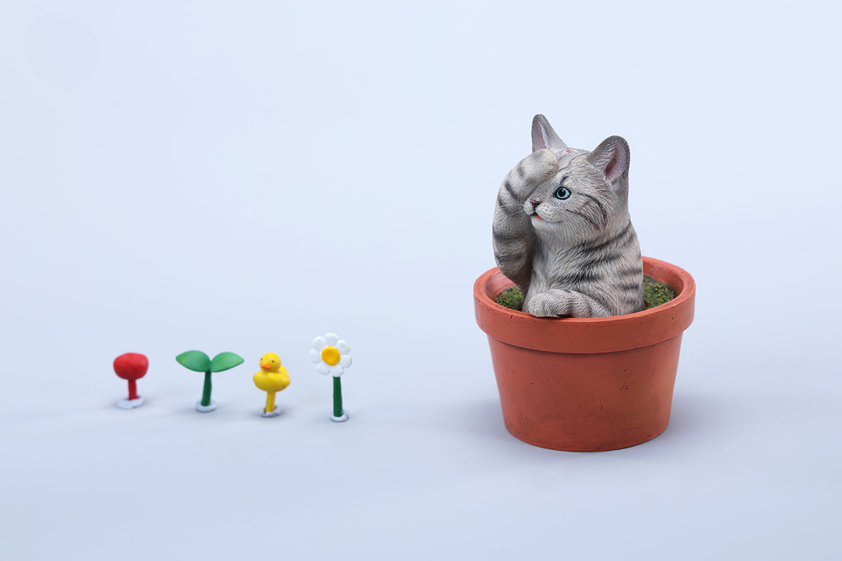 This charming Flower Pot Cat Model features a playful kitten peeking out of a terracotta pot with a small yellow rubber duck on its head. The series includes multiple variations, each with a different accessory atop the cat's head. This delightful ornament brings a touch of whimsy and cheer to any space, perfect for cat lovers and collectors alike. The detailed craftsmanship and vibrant colors make it a standout piece in any collection.