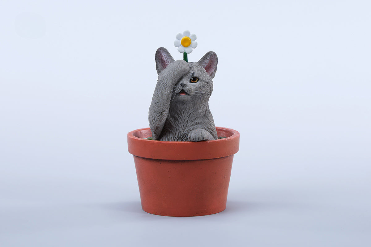 This charming Flower Pot Cat Model features a playful kitten peeking out of a terracotta pot with a small yellow rubber duck on its head. The series includes multiple variations, each with a different accessory atop the cat's head. This delightful ornament brings a touch of whimsy and cheer to any space, perfect for cat lovers and collectors alike. The detailed craftsmanship and vibrant colors make it a standout piece in any collection.