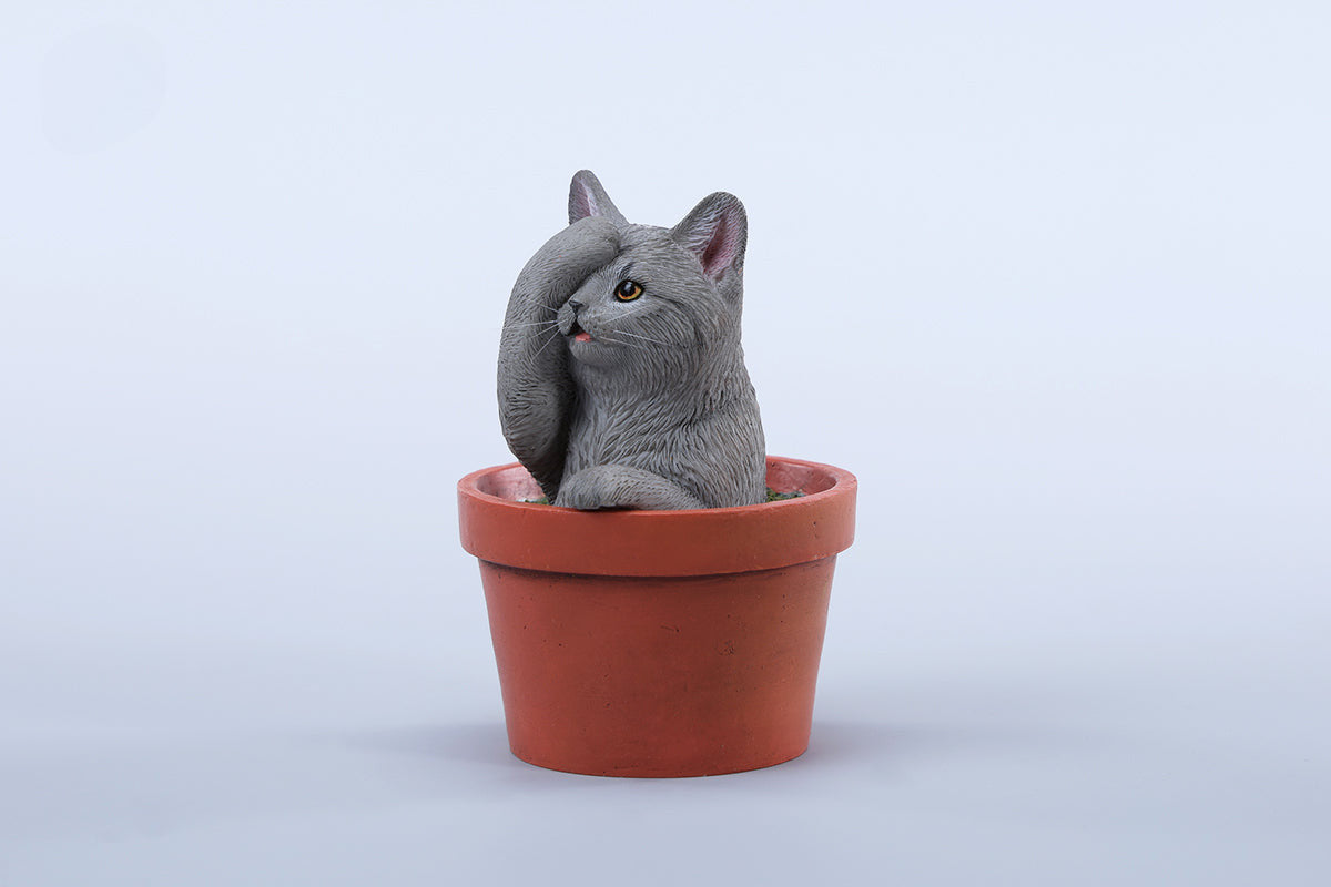 This charming Flower Pot Cat Model features a playful kitten peeking out of a terracotta pot with a small yellow rubber duck on its head. The series includes multiple variations, each with a different accessory atop the cat's head. This delightful ornament brings a touch of whimsy and cheer to any space, perfect for cat lovers and collectors alike. The detailed craftsmanship and vibrant colors make it a standout piece in any collection.