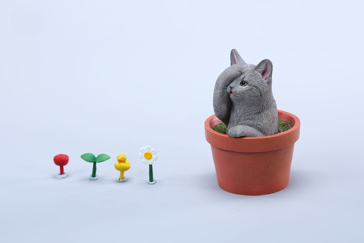 This charming Flower Pot Cat Model features a playful kitten peeking out of a terracotta pot with a small yellow rubber duck on its head. The series includes multiple variations, each with a different accessory atop the cat's head. This delightful ornament brings a touch of whimsy and cheer to any space, perfect for cat lovers and collectors alike. The detailed craftsmanship and vibrant colors make it a standout piece in any collection.