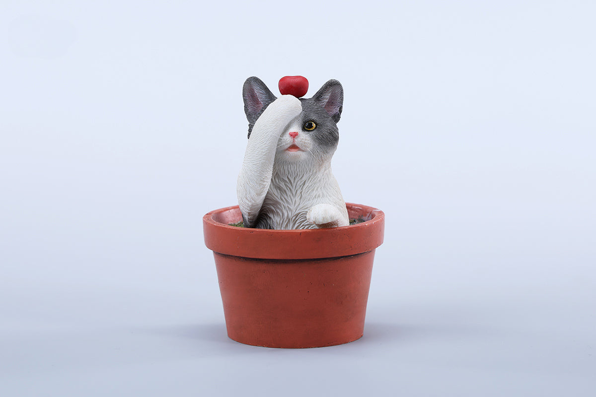 This charming Flower Pot Cat Model features a playful kitten peeking out of a terracotta pot with a small yellow rubber duck on its head. The series includes multiple variations, each with a different accessory atop the cat's head. This delightful ornament brings a touch of whimsy and cheer to any space, perfect for cat lovers and collectors alike. The detailed craftsmanship and vibrant colors make it a standout piece in any collection.