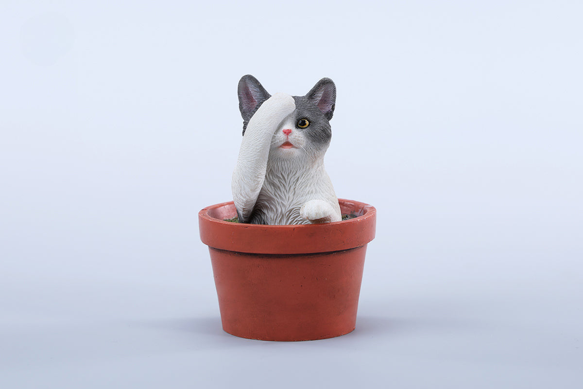 This charming Flower Pot Cat Model features a playful kitten peeking out of a terracotta pot with a small yellow rubber duck on its head. The series includes multiple variations, each with a different accessory atop the cat's head. This delightful ornament brings a touch of whimsy and cheer to any space, perfect for cat lovers and collectors alike. The detailed craftsmanship and vibrant colors make it a standout piece in any collection.