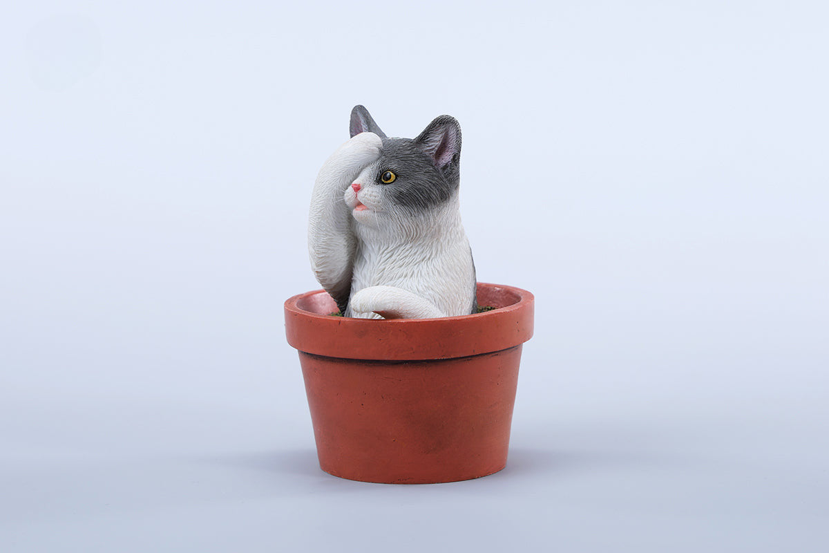 This charming Flower Pot Cat Model features a playful kitten peeking out of a terracotta pot with a small yellow rubber duck on its head. The series includes multiple variations, each with a different accessory atop the cat's head. This delightful ornament brings a touch of whimsy and cheer to any space, perfect for cat lovers and collectors alike. The detailed craftsmanship and vibrant colors make it a standout piece in any collection.