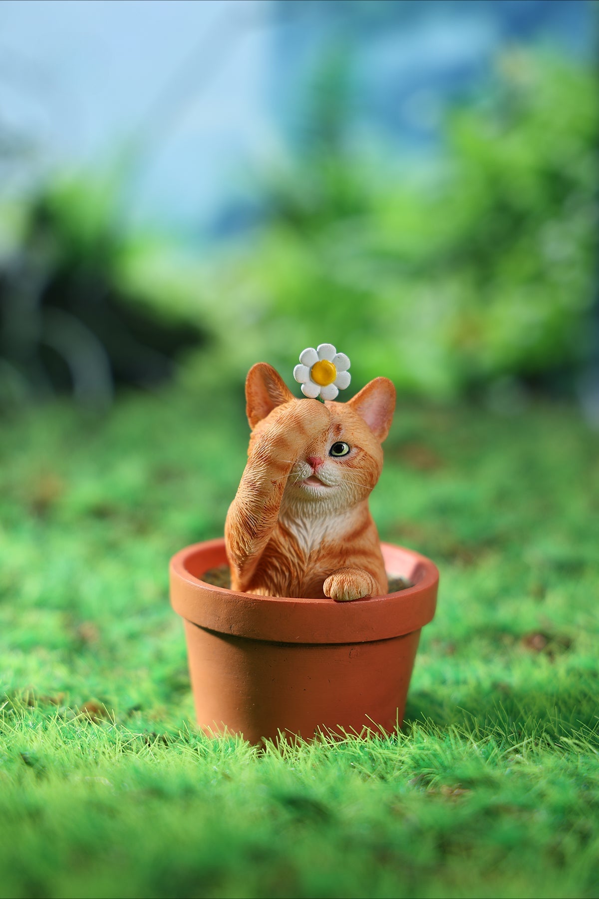 This charming Flower Pot Cat Model features a playful kitten peeking out of a terracotta pot with a small yellow rubber duck on its head. The series includes multiple variations, each with a different accessory atop the cat's head. This delightful ornament brings a touch of whimsy and cheer to any space, perfect for cat lovers and collectors alike. The detailed craftsmanship and vibrant colors make it a standout piece in any collection.