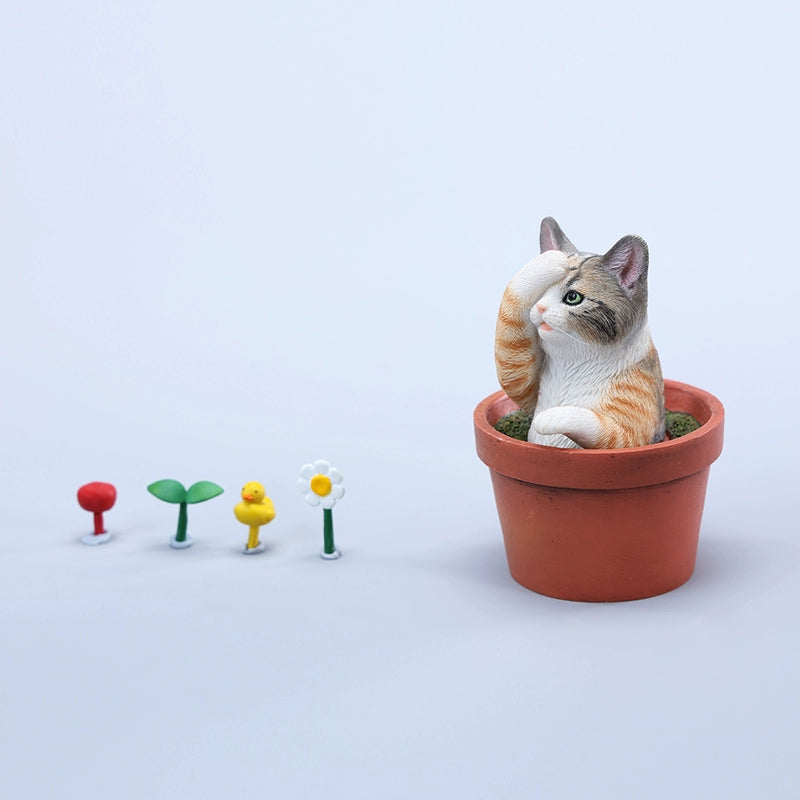 This charming Flower Pot Cat Model features a playful kitten peeking out of a terracotta pot with a small yellow rubber duck on its head. The series includes multiple variations, each with a different accessory atop the cat's head. This delightful ornament brings a touch of whimsy and cheer to any space, perfect for cat lovers and collectors alike. The detailed craftsmanship and vibrant colors make it a standout piece in any collection.