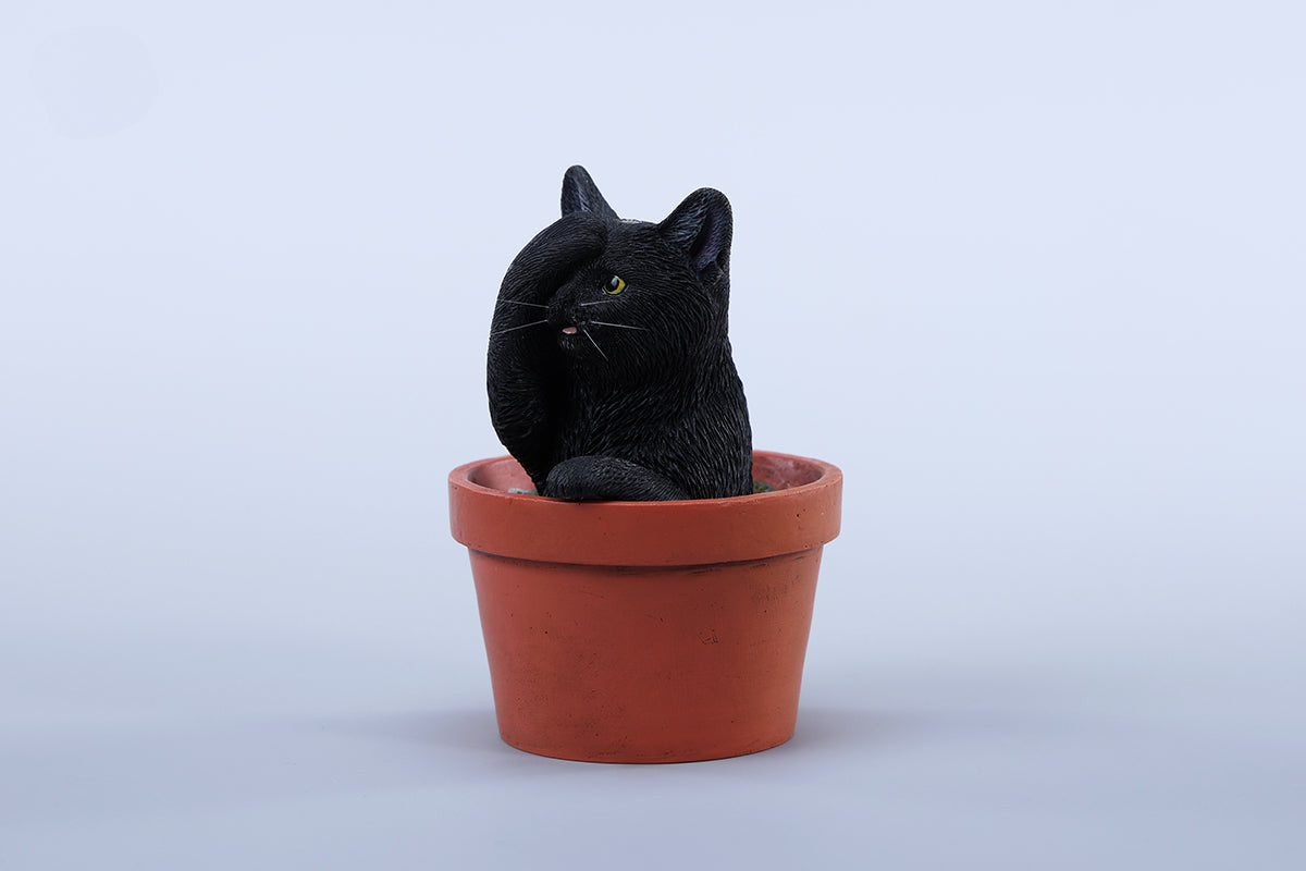 This charming Flower Pot Cat Model features a playful kitten peeking out of a terracotta pot with a small yellow rubber duck on its head. The series includes multiple variations, each with a different accessory atop the cat's head. This delightful ornament brings a touch of whimsy and cheer to any space, perfect for cat lovers and collectors alike. The detailed craftsmanship and vibrant colors make it a standout piece in any collection.