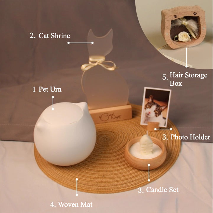 White ceramic cat-shaped pet cremation urn set with personalized memorial plaque, candle holder, fur keepsake box, photo stand, and woven mat, designed for home ashes storage and display.
