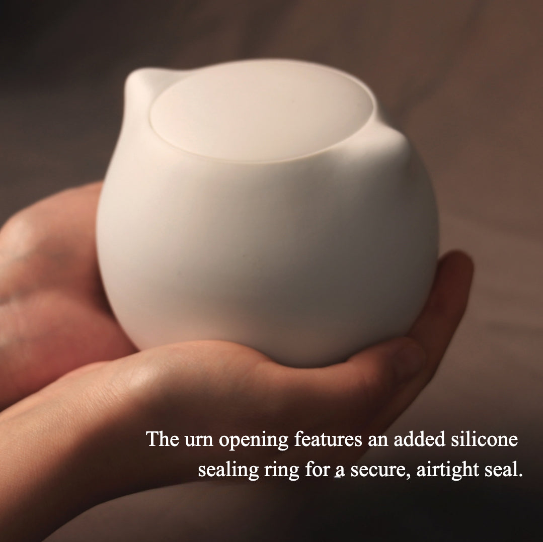 This white cat ceramic pet urn features a charming cat-shaped design with a detachable photo frame and included candle, measuring 15cm tall and 10cm wide, holding 200ml of ashes. Perfect for North American pet owners memorializing small pets like cats or kittens, it offers secure storage and a heartfelt display for shelves or mantels.