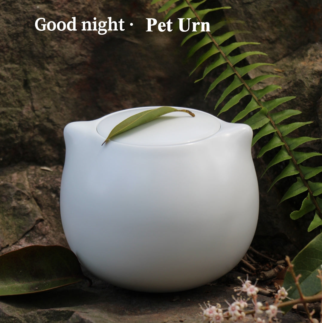 This white cat ceramic pet urn features a charming cat-shaped design with a detachable photo frame and included candle, measuring 15cm tall and 10cm wide, holding 200ml of ashes. Perfect for North American pet owners memorializing small pets like cats or kittens, it offers secure storage and a heartfelt display for shelves or mantels.