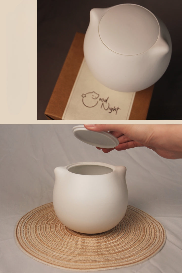 This white cat ceramic pet urn features a charming cat-shaped design with a detachable photo frame and included candle, measuring 15cm tall and 10cm wide, holding 200ml of ashes. Perfect for North American pet owners memorializing small pets like cats or kittens, it offers secure storage and a heartfelt display for shelves or mantels.