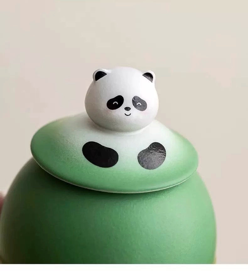 This green panda pet urn showcases a cute round ceramic design with a playful panda figurine on top, measuring 12.5cm wide, 11cm tall, and 9.1cm in diameter, holding 290ml of ashes. Ideal for North American pet owners honoring small pets like cats or dogs, it offers secure storage and a warm memorial display, fitting perfectly on shelves or mantels.