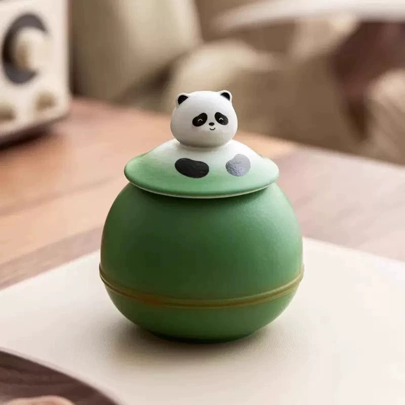 This green panda pet urn showcases a cute round ceramic design with a playful panda figurine on top, measuring 12.5cm wide, 11cm tall, and 9.1cm in diameter, holding 290ml of ashes. Ideal for North American pet owners honoring small pets like cats or dogs, it offers secure storage and a warm memorial display, fitting perfectly on shelves or mantels.