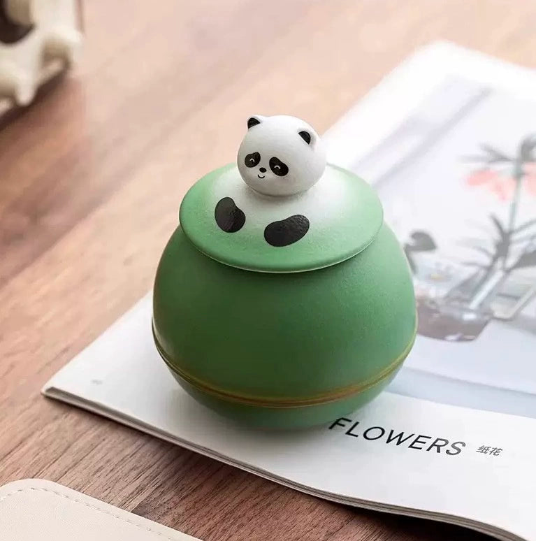 This green panda pet urn showcases a cute round ceramic design with a playful panda figurine on top, measuring 12.5cm wide, 11cm tall, and 9.1cm in diameter, holding 290ml of ashes. Ideal for North American pet owners honoring small pets like cats or dogs, it offers secure storage and a warm memorial display, fitting perfectly on shelves or mantels.