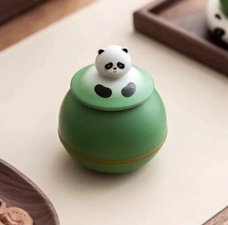 This green panda pet urn showcases a cute round ceramic design with a playful panda figurine on top, measuring 12.5cm wide, 11cm tall, and 9.1cm in diameter, holding 290ml of ashes. Ideal for North American pet owners honoring small pets like cats or dogs, it offers secure storage and a warm memorial display, fitting perfectly on shelves or mantels.