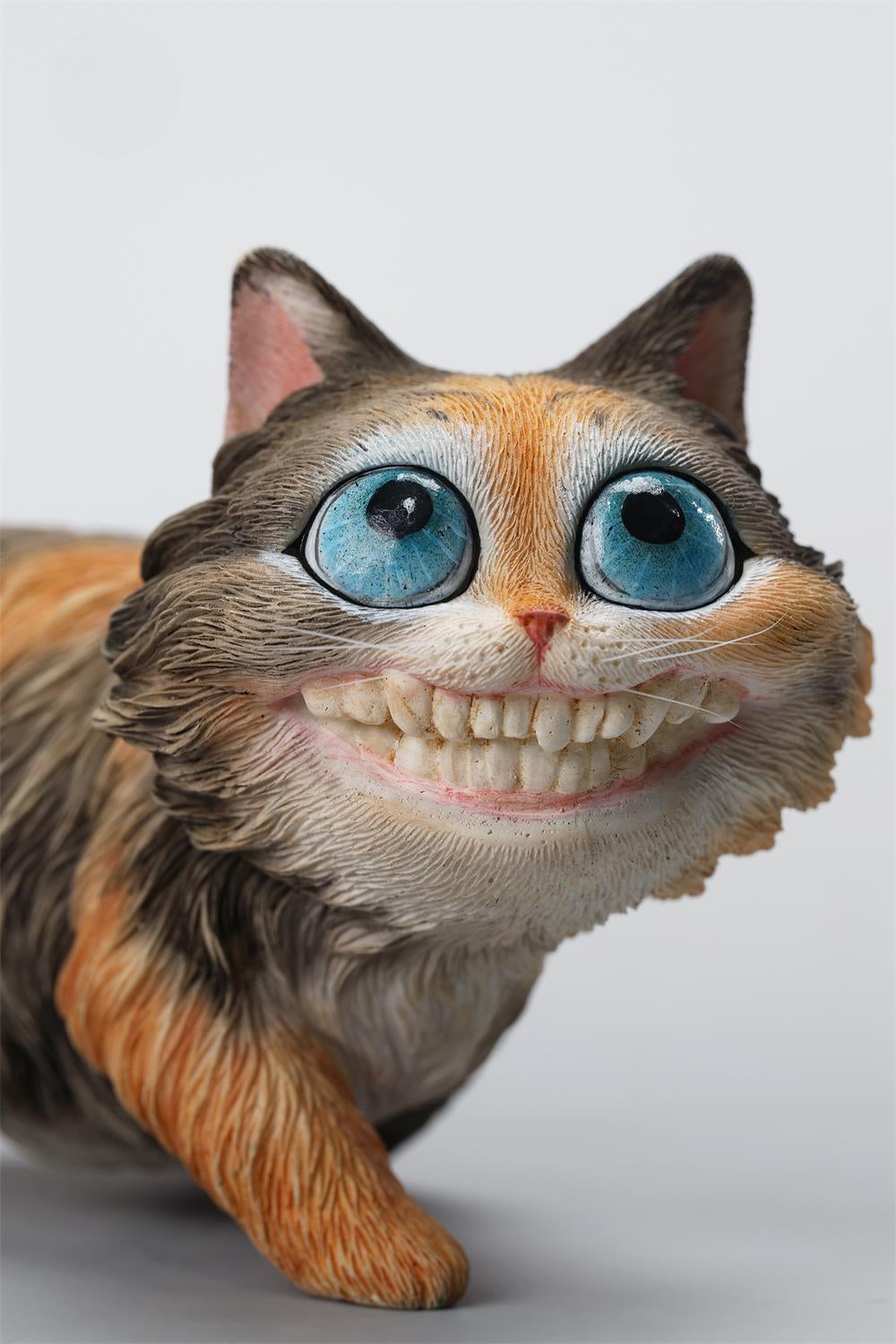 A highly detailed grinning cat resin figurine with expressive eyes, textured fur, and a wide smile. This unique decorative sculpture includes a bone pendant necklace and serves as a quirky, surreal home decor piece or collectible item for cat lovers and fantasy art fans.