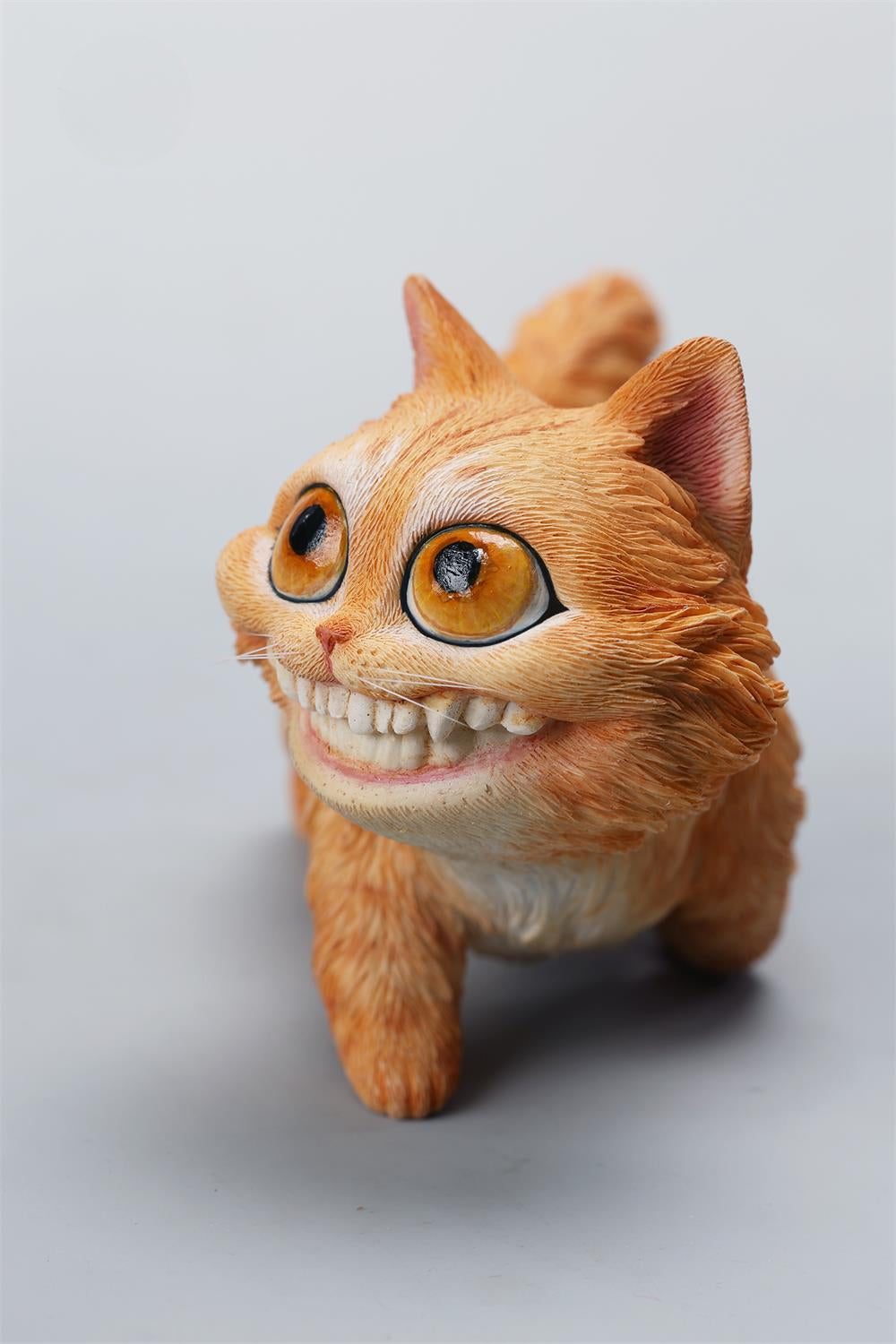 A highly detailed grinning cat resin figurine with expressive eyes, textured fur, and a wide smile. This unique decorative sculpture includes a bone pendant necklace and serves as a quirky, surreal home decor piece or collectible item for cat lovers and fantasy art fans.