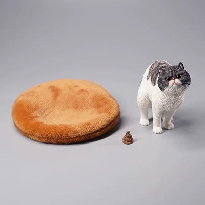 A detailed resin model of a Garfield cat in a half-squat position, poised above a plush bed. The cat, rendered with realistic fur texture and markings, appears lifelike and is captured mid-action. The scene includes a playful addition, making it an amusing piece for collectors and cat lovers alike.