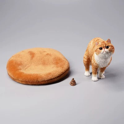 A detailed resin model of a Garfield cat in a half-squat position, poised above a plush bed. The cat, rendered with realistic fur texture and markings, appears lifelike and is captured mid-action. The scene includes a playful addition, making it an amusing piece for collectors and cat lovers alike.