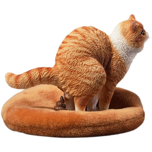 A detailed resin model of a Garfield cat in a half-squat position, poised above a plush bed. The cat, rendered with realistic fur texture and markings, appears lifelike and is captured mid-action. The scene includes a playful addition, making it an amusing piece for collectors and cat lovers alike.