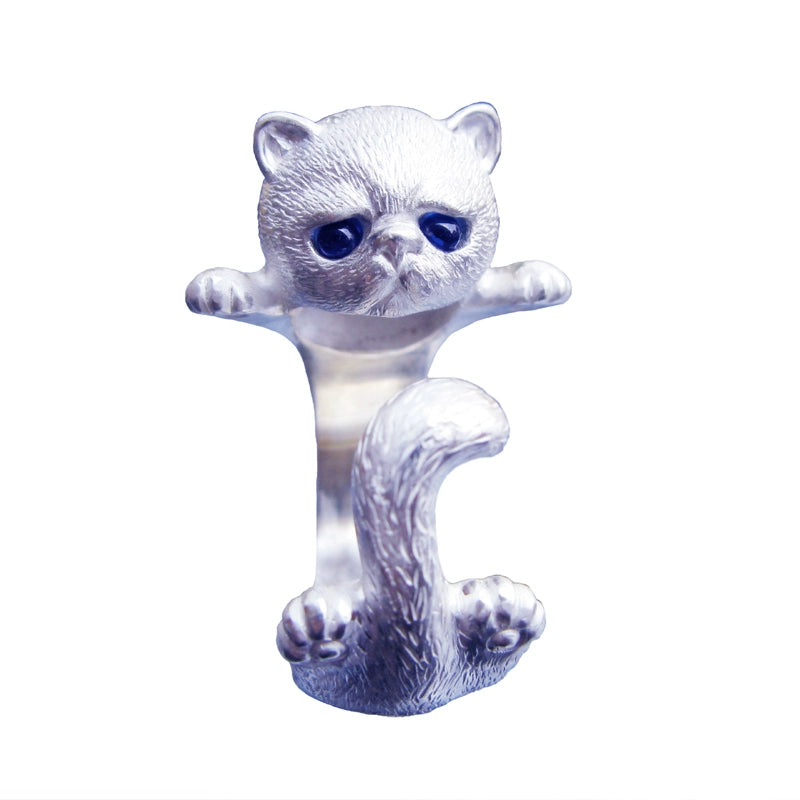 A meticulously handcrafted 925 silver cat ring featuring blue corundum gemstone eyes. The ring showcases intricate hand-carved fur details and an adjustable design, perfect for commemorating your beloved pet with a personalized engraving. Each piece is unique, with slight variations in color and size, making it a truly one-of-a-kind jewelry item.