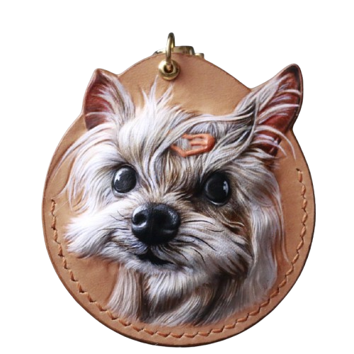 This beautifully handcrafted droplet-shaped pet leather carving showcases a detailed portrait of a small dog with lifelike features. The artwork captures the dog's expressive eyes and fur texture, making it a perfect keepsake for dog lovers. Crafted with precision and care, this custom leather carving is ideal for personalizing your accessories or gifting to a pet owner. The unique droplet shape adds a touch of elegance to this one-of-a-kind piece.