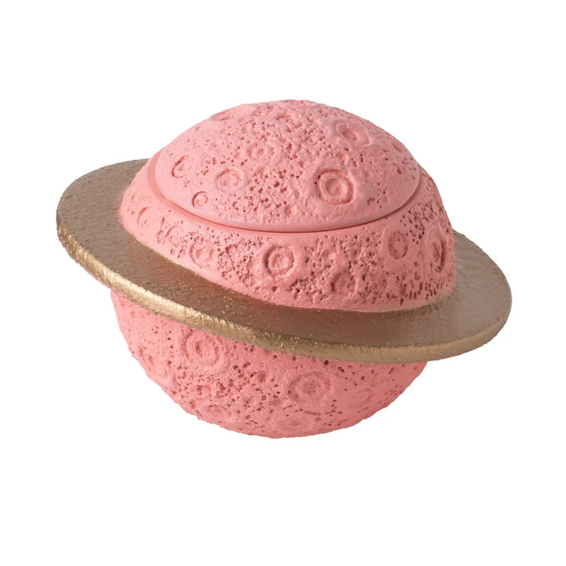 Discover the Pink Saturn-Shaped Pet Urn, a heartfelt memorial ashes holder crafted from durable Portland cement for North American pet owners. This whimsical planet-inspired design in soft pink, complete with a gold ring and textured craters, offers secure storage for up to 400ml of ashes from small pets. Measuring 16.5cm wide and 11cm tall, it weighs 1010g and fits perfectly on shelves or mantels, blending seamlessly into home decor. Ideal for cat or dog lovers seeking a unique tribute, it addresses grief 