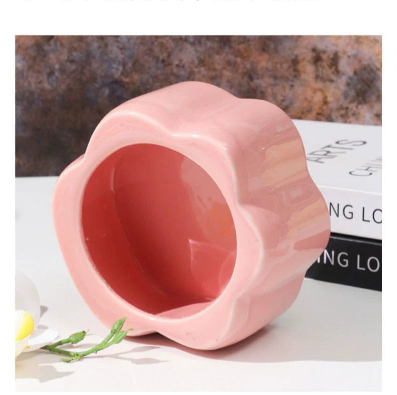 This pink and black paw ceramic pet urn features a stylish paw print lid, available in soft pink or sleek black, measuring approximately 12cm tall and 10cm wide. Crafted from durable ceramic, it offers secure storage for ashes of small to medium pets like cats or dogs, making it a heartfelt memorial display for North American pet owners on shelves or tables.